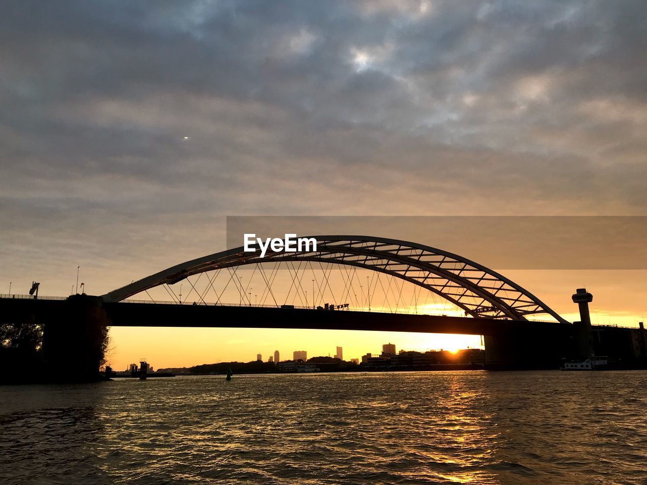 VIEW OF BRIDGE OVER RIVER AGAINST SKY DURING SUNSET