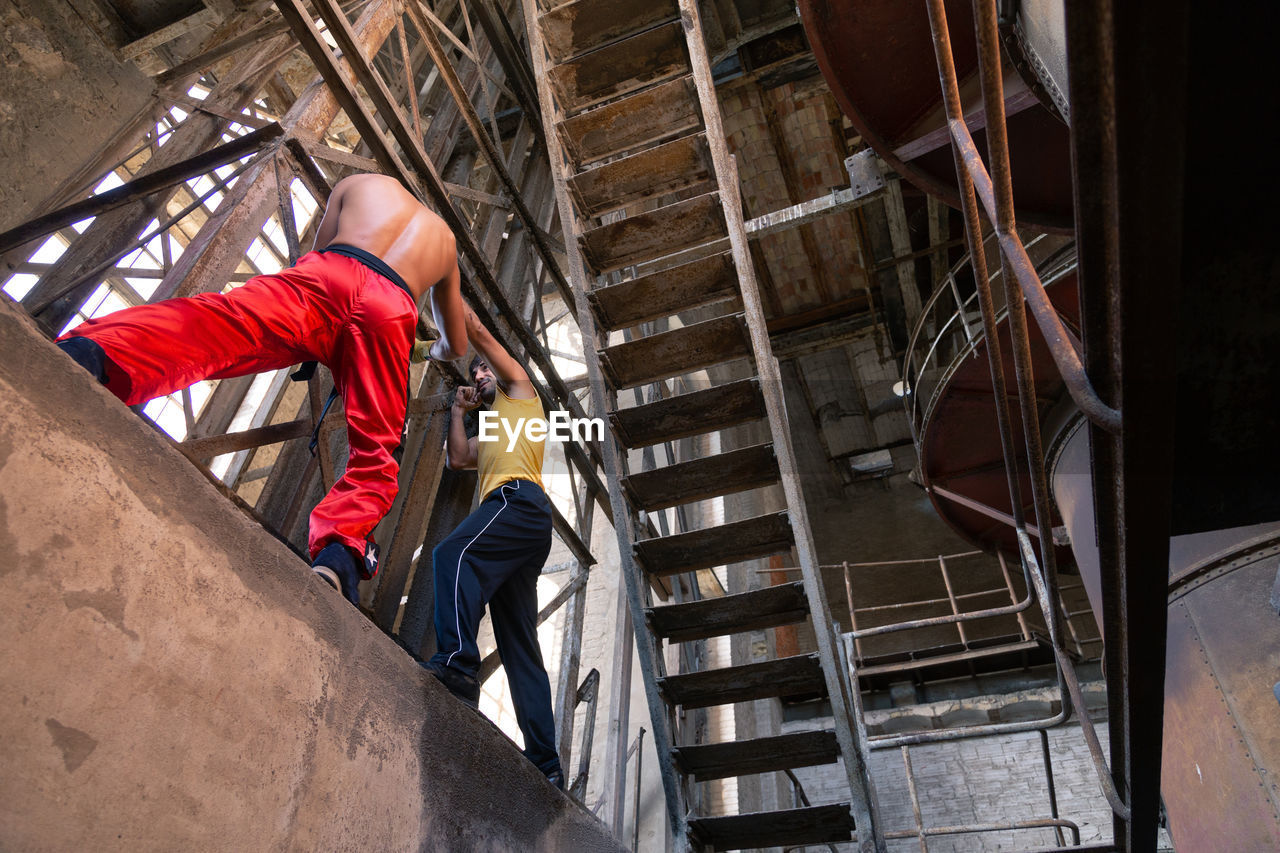 Low angle view of men boxing on staircase