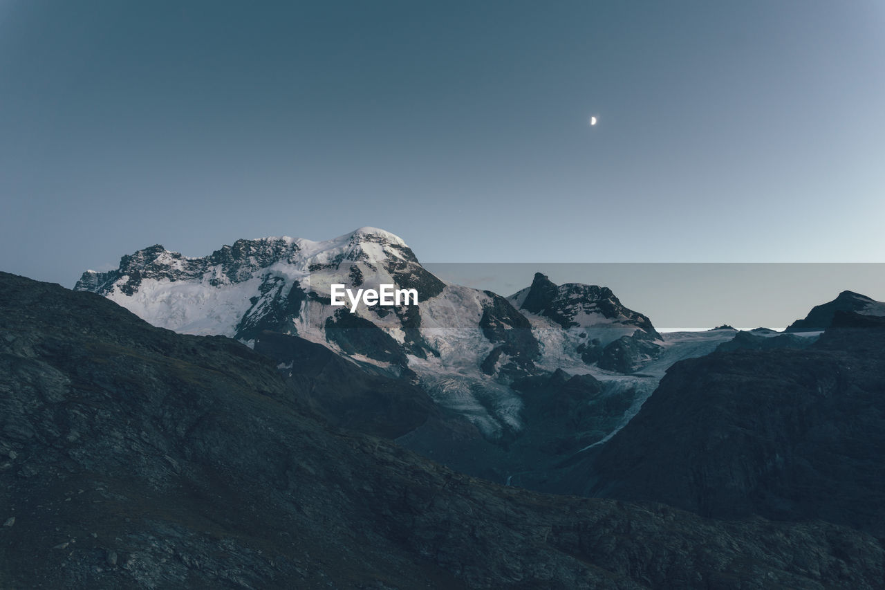 Scenic view of mountains against clear sky during sunset at swiss alps