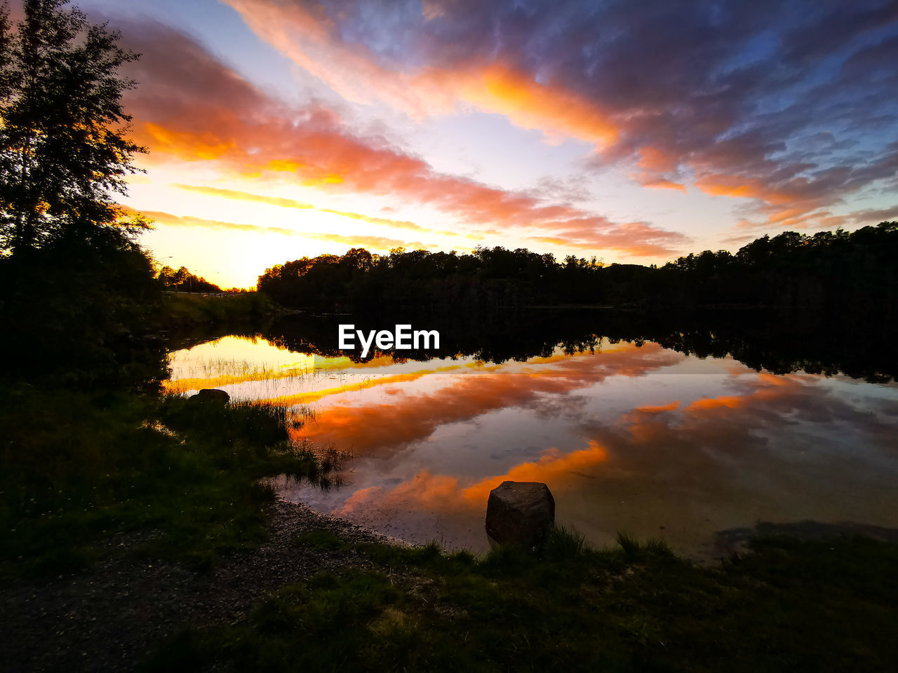 sky, water, reflection, tree, cloud, sunset, beauty in nature, scenics - nature, dawn, plant, nature, evening, environment, tranquility, landscape, no people, tranquil scene, sunlight, land, lake, forest, orange color, outdoors, silhouette, sun, non-urban scene, idyllic, travel destinations, afterglow