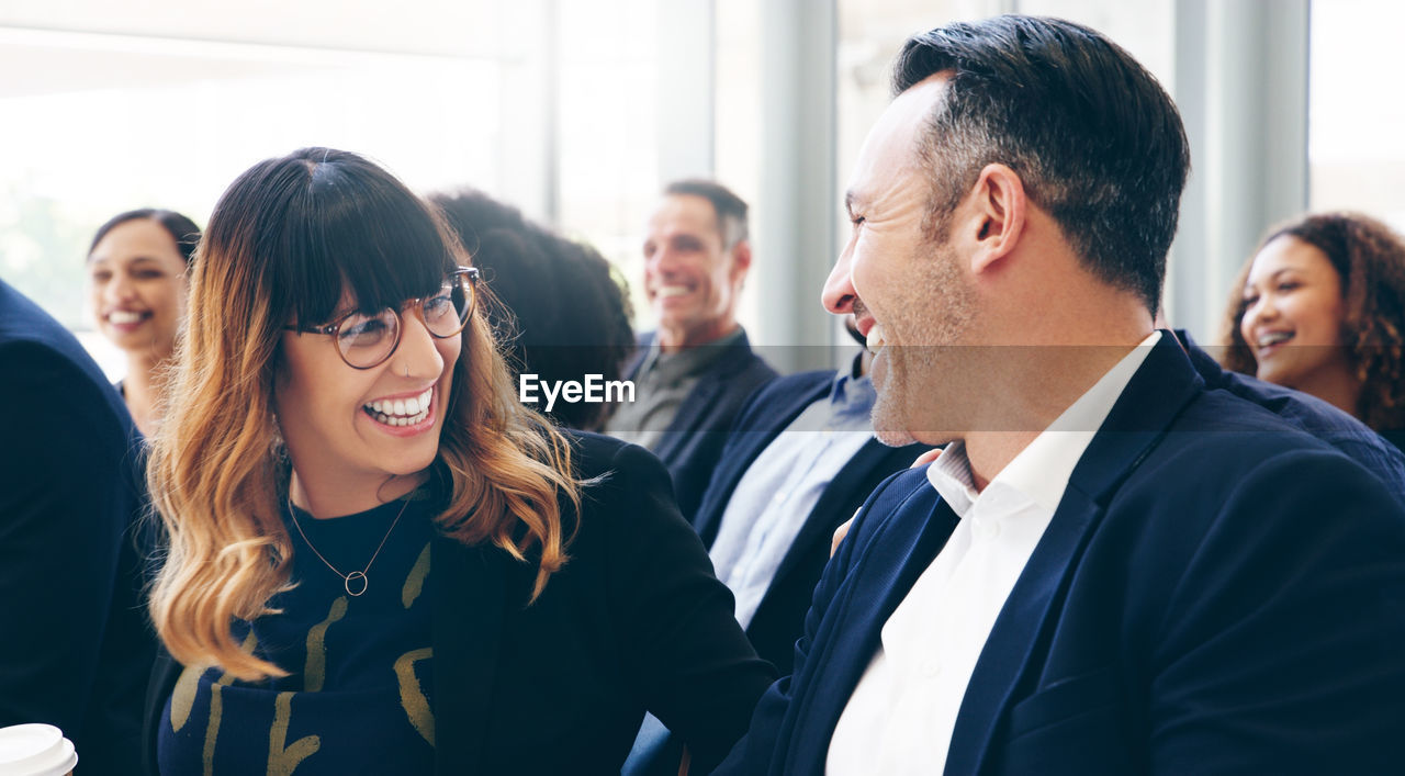 Male and female colleagues laughing in seminar