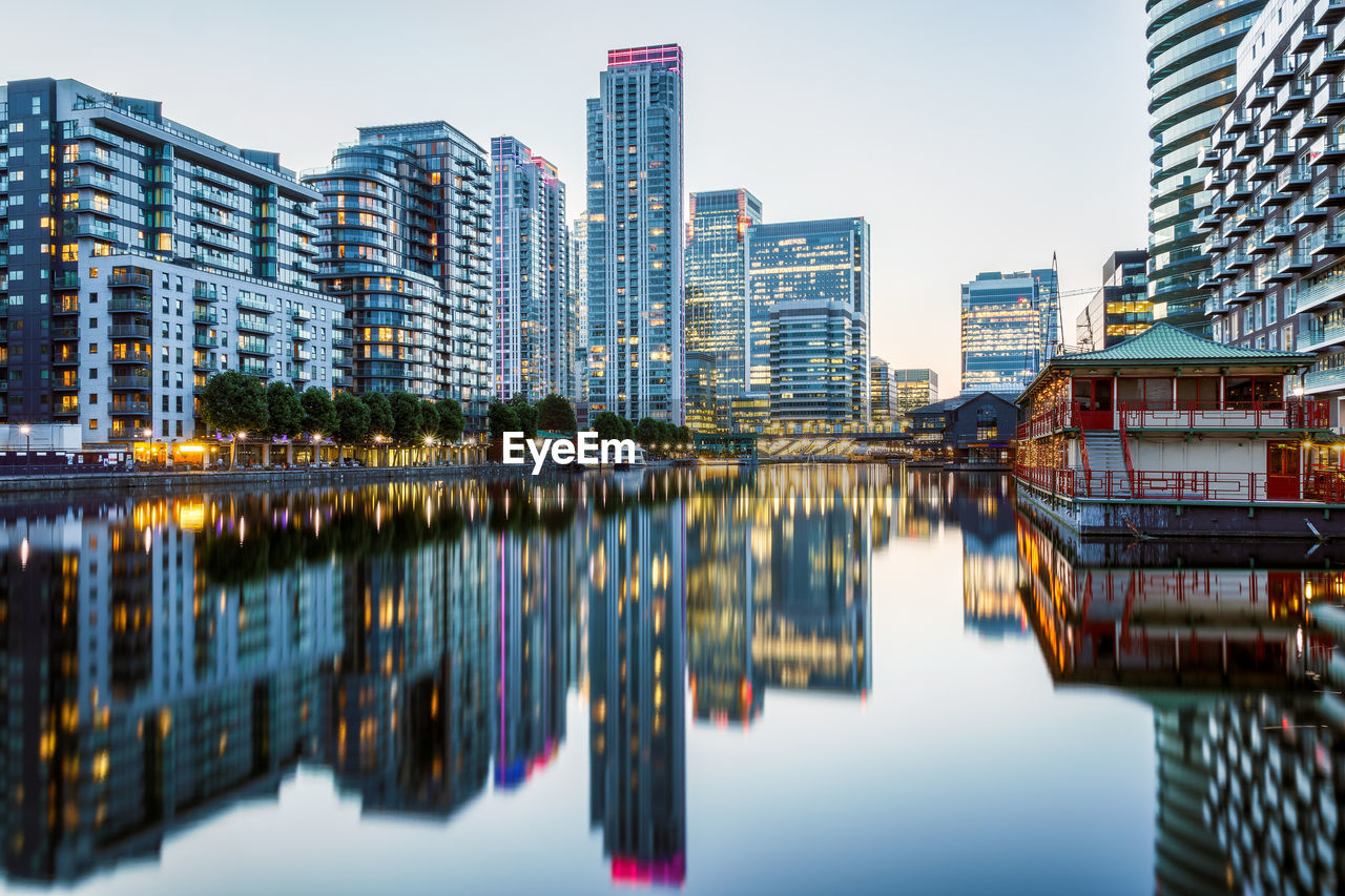 Reflection of buildings in river against sky