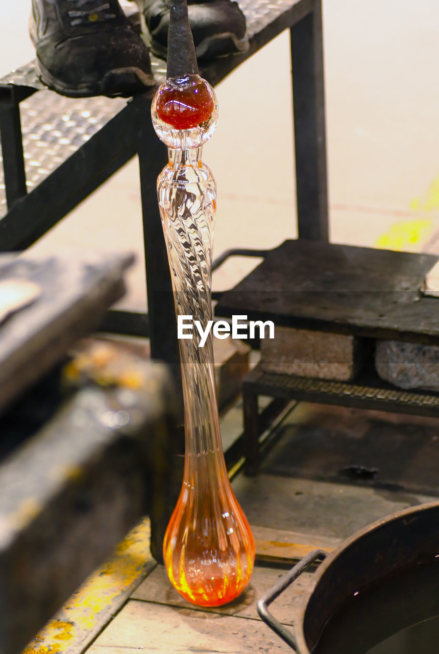 Glass blowing by man blowers working the craft of making glassware by blowing air inside