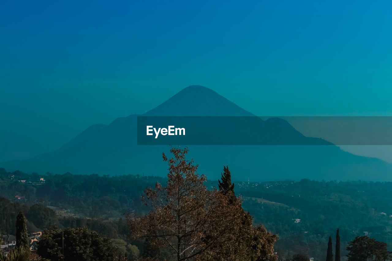 SCENIC VIEW OF TREE MOUNTAINS AGAINST BLUE SKY