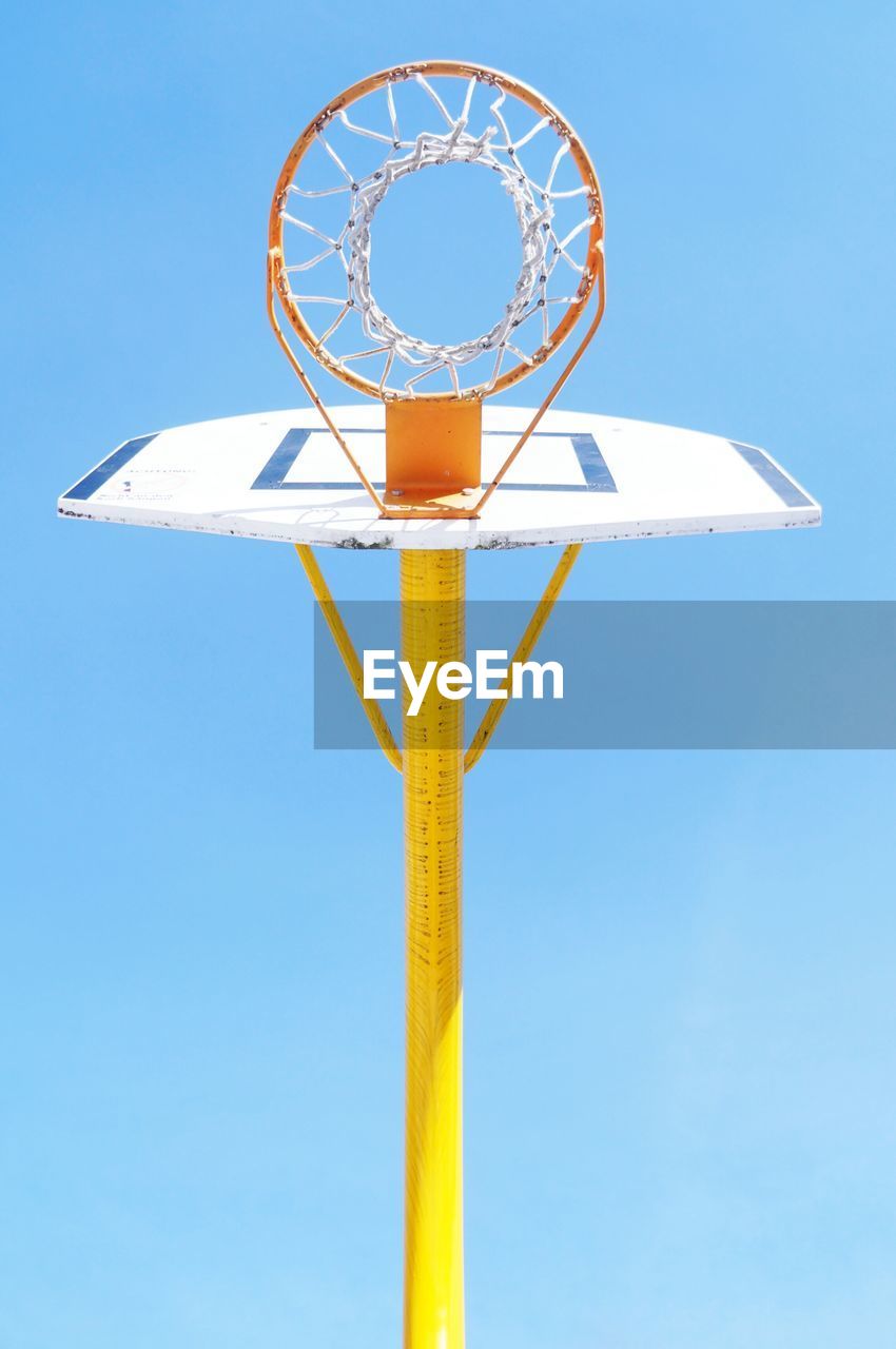 Low angle view of basketball hoop against clear blue sky