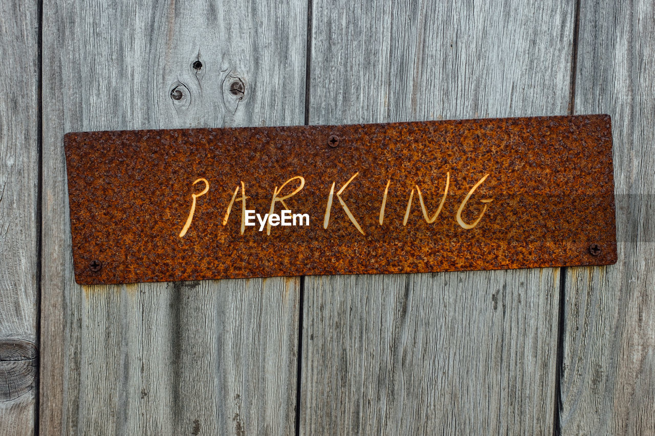 Close-up of text on wooden door - parking
