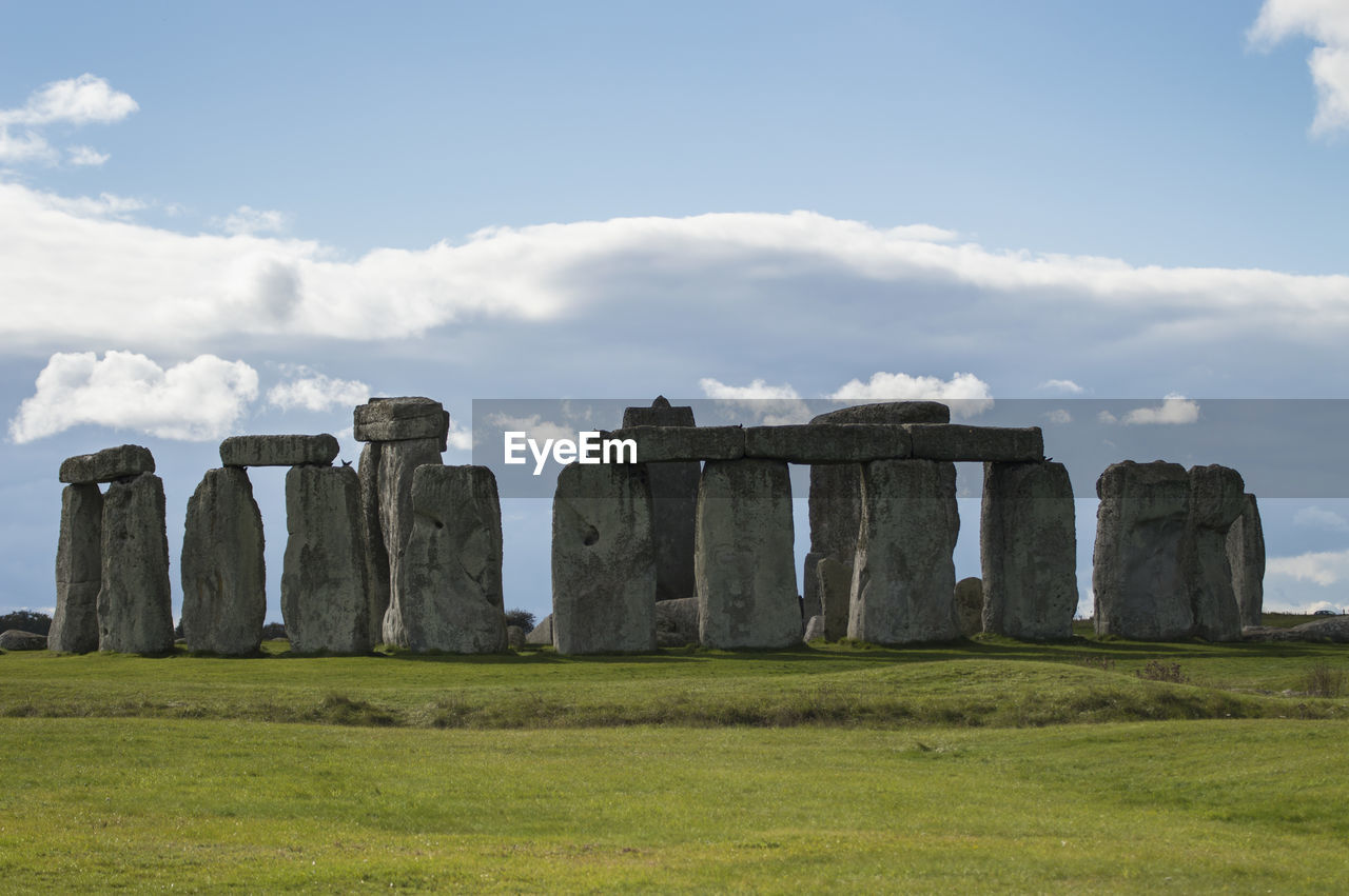 Built structure on landscape against cloudy sky