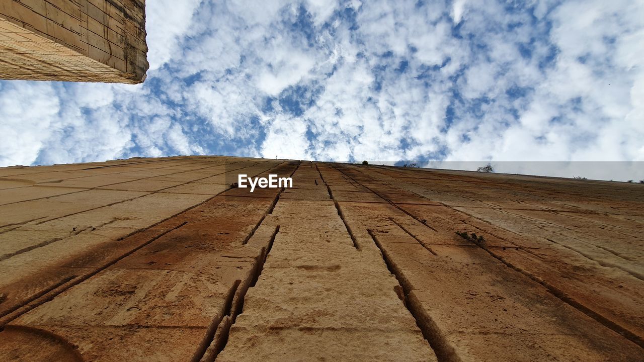 LOW ANGLE VIEW OF ROOF AGAINST CLOUDY SKY