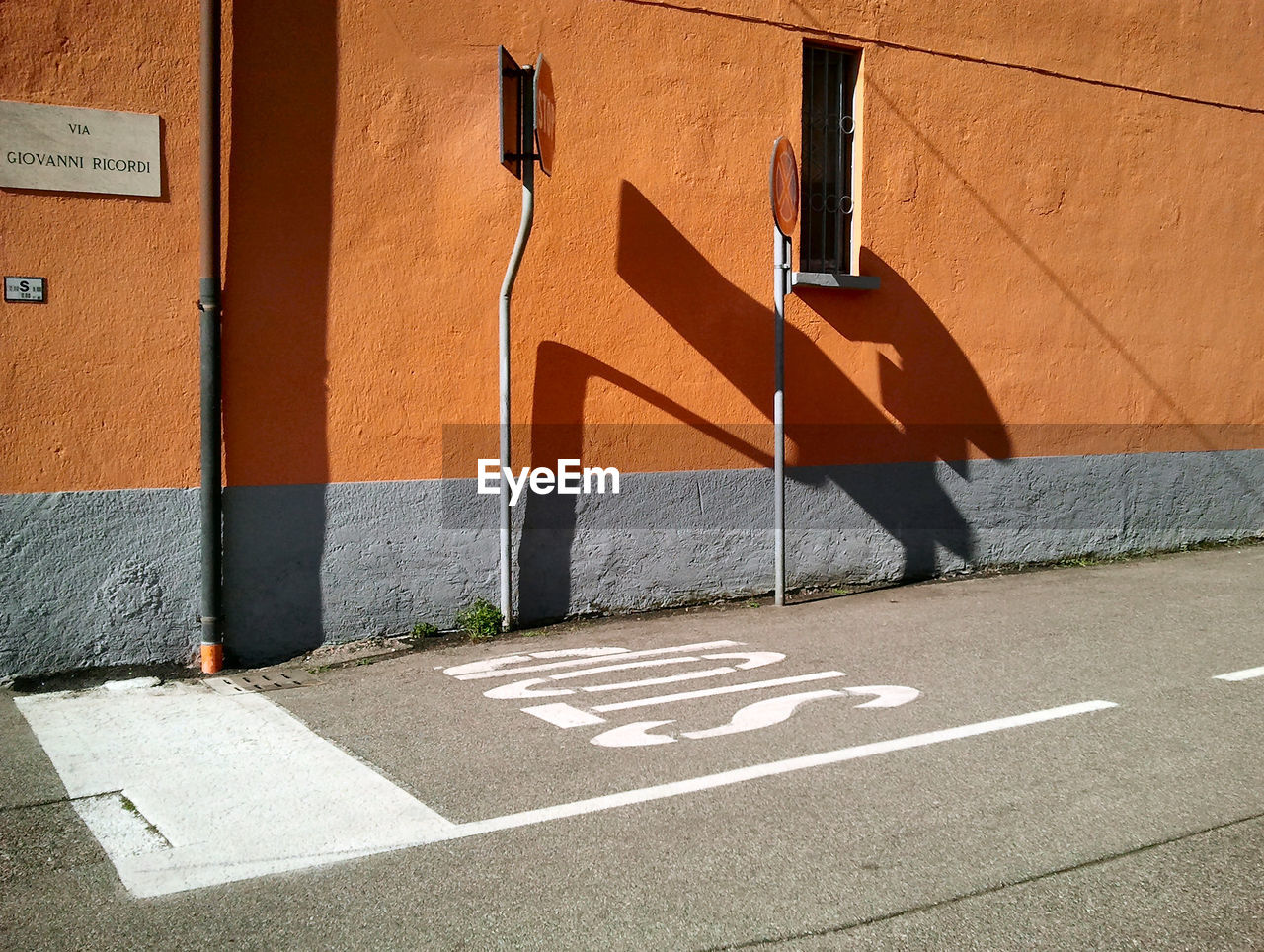 Road signs against orange wall