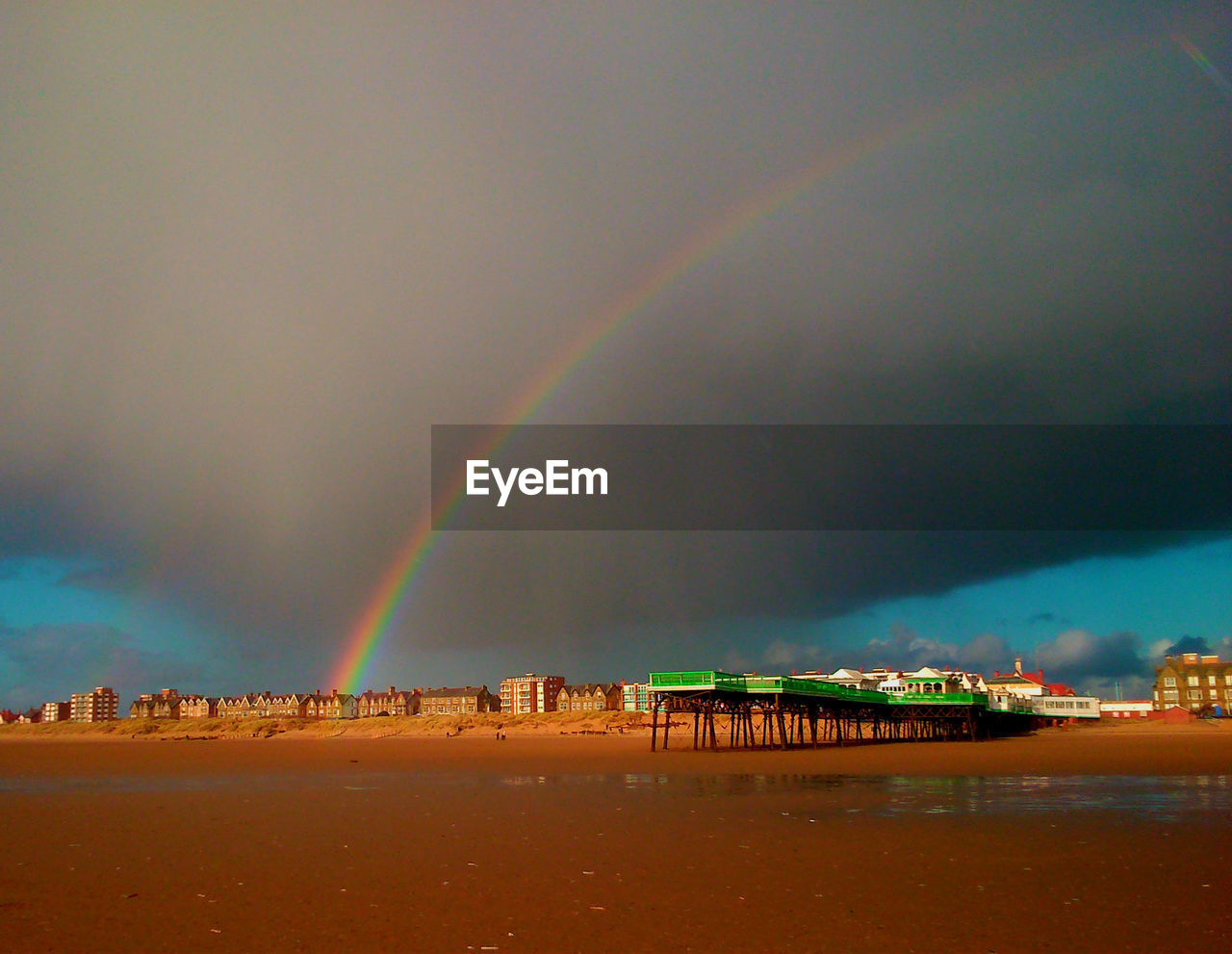 SCENIC VIEW OF RAINBOW OVER CITY AT SUNSET