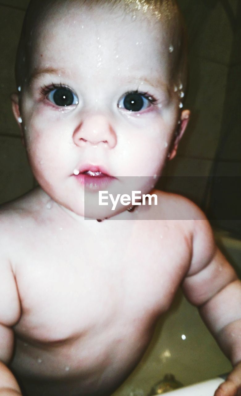 Close-up portrait of baby boy in bathtub