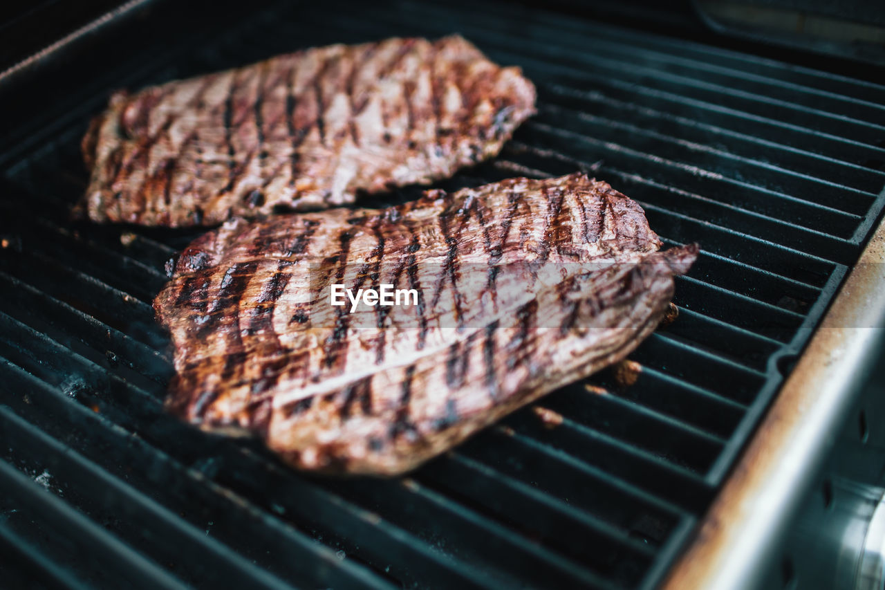 HIGH ANGLE VIEW OF MEAT COOKING ON BARBECUE