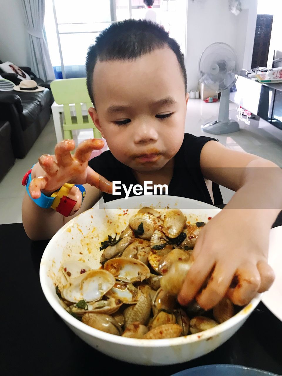Close-up of boy eating food from bowl at home