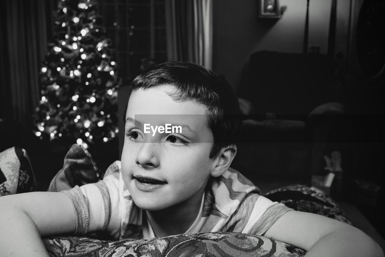 Boy by christmas tree at home