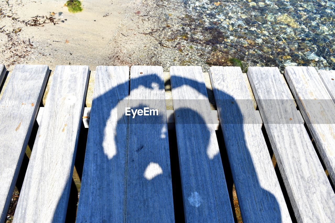 HIGH ANGLE VIEW OF SHADOW ON BOARDWALK