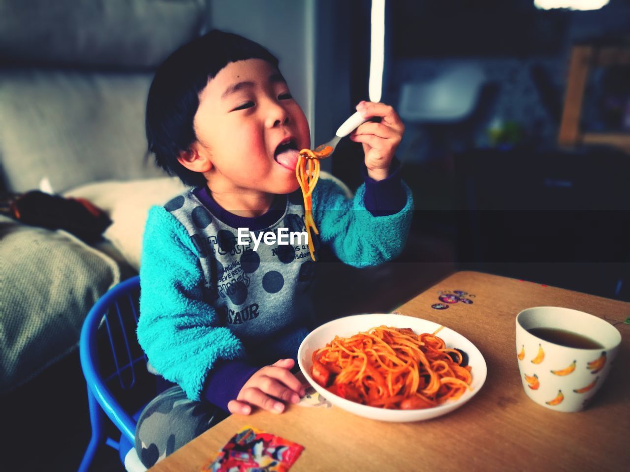 Close-up of cute baby boy eating food at home