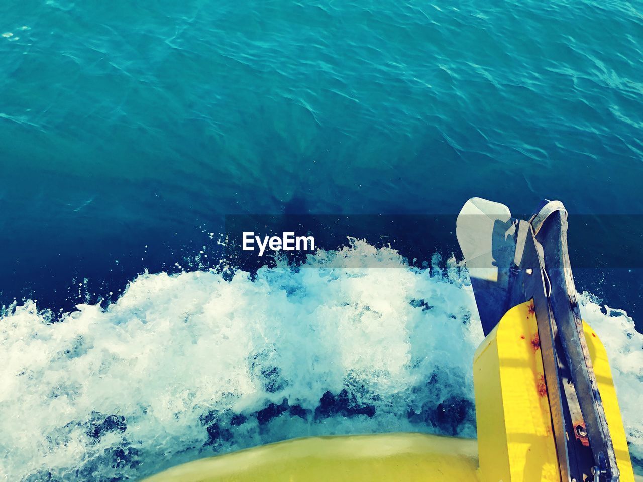 CLOSE-UP OF YELLOW WATER SPLASHING ON BOAT