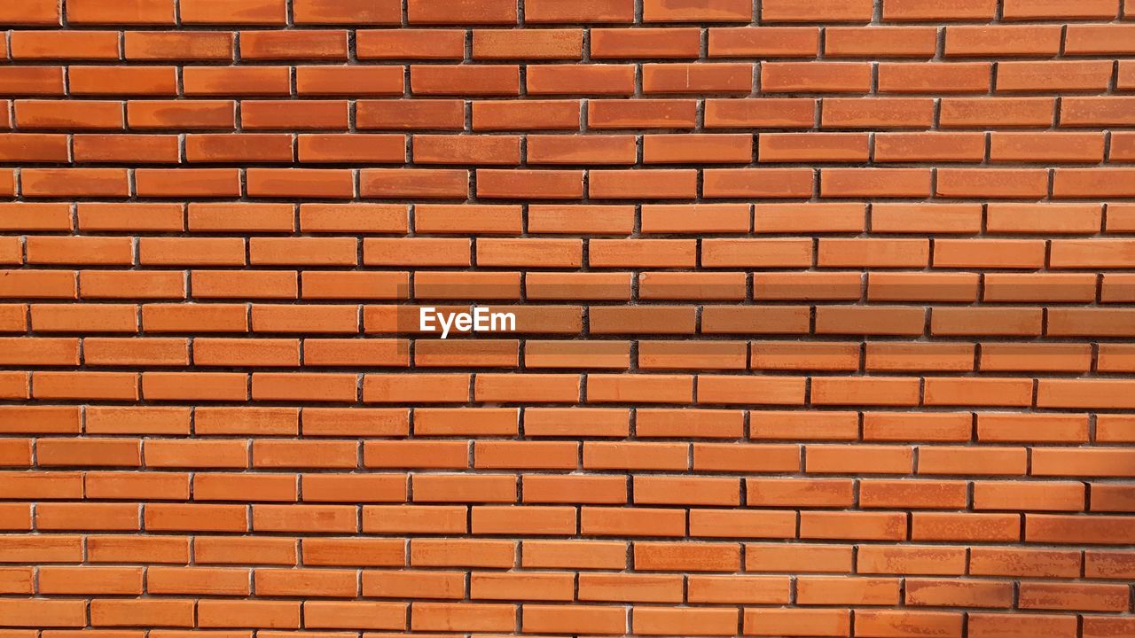 FULL FRAME SHOT OF BRICK WALL WITH ORANGE WALLS