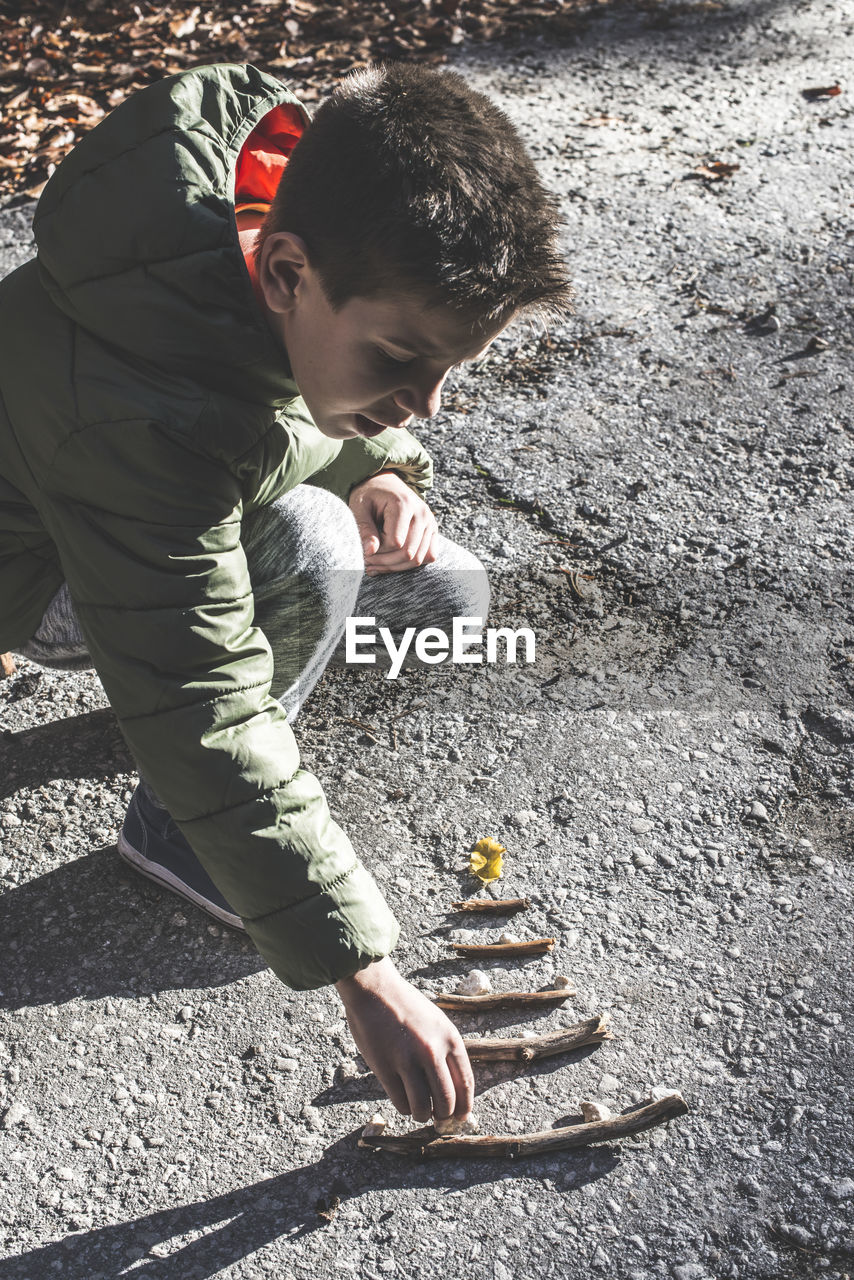 High angle view of boy playing arranging on road