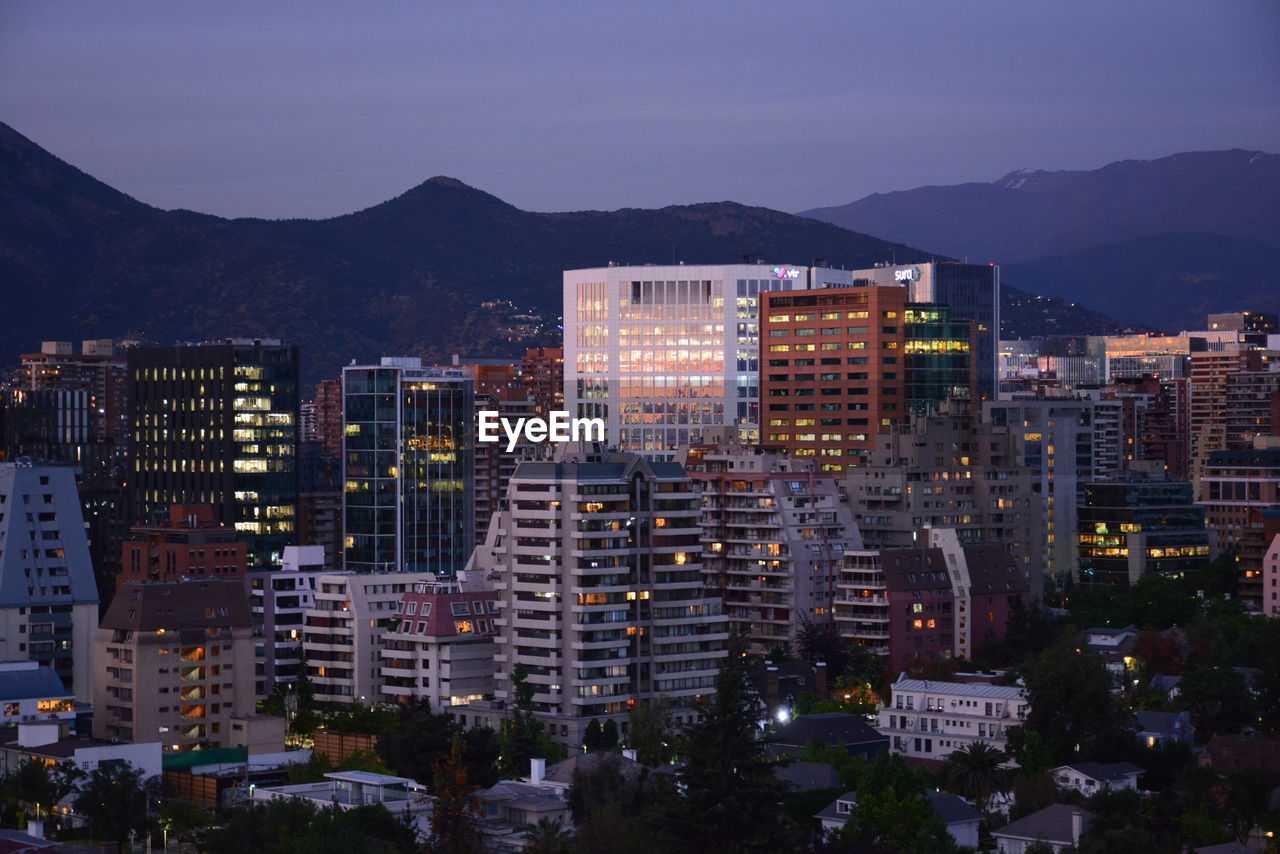 Buildings in city against sky at dusk