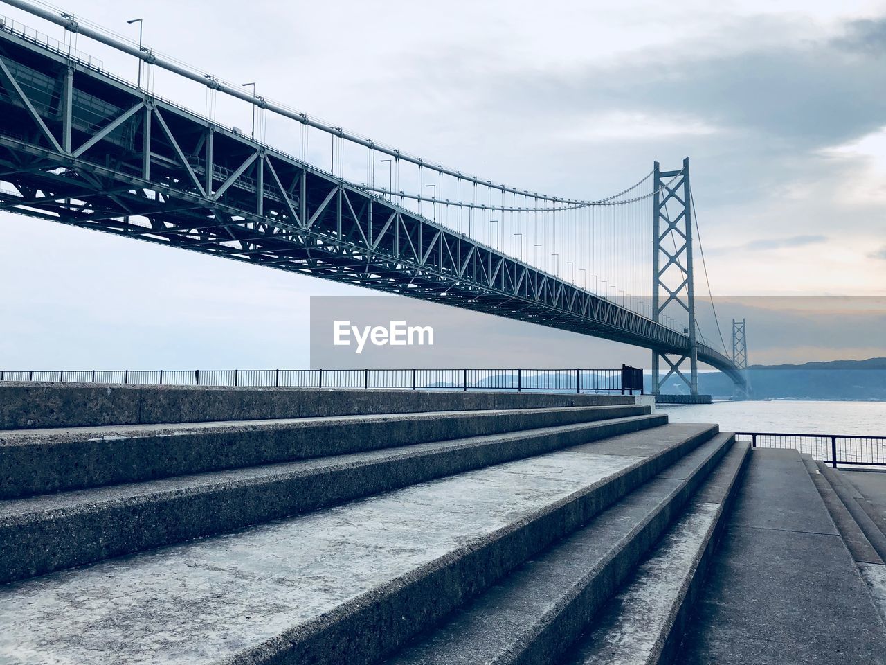 View of suspension bridge against cloudy sky