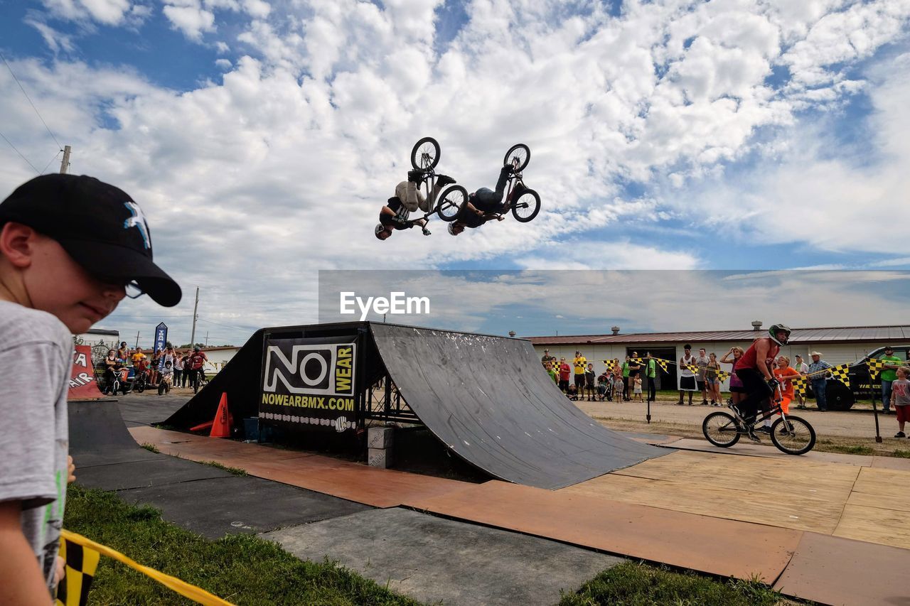 MAN RIDING BICYCLE AGAINST SKY