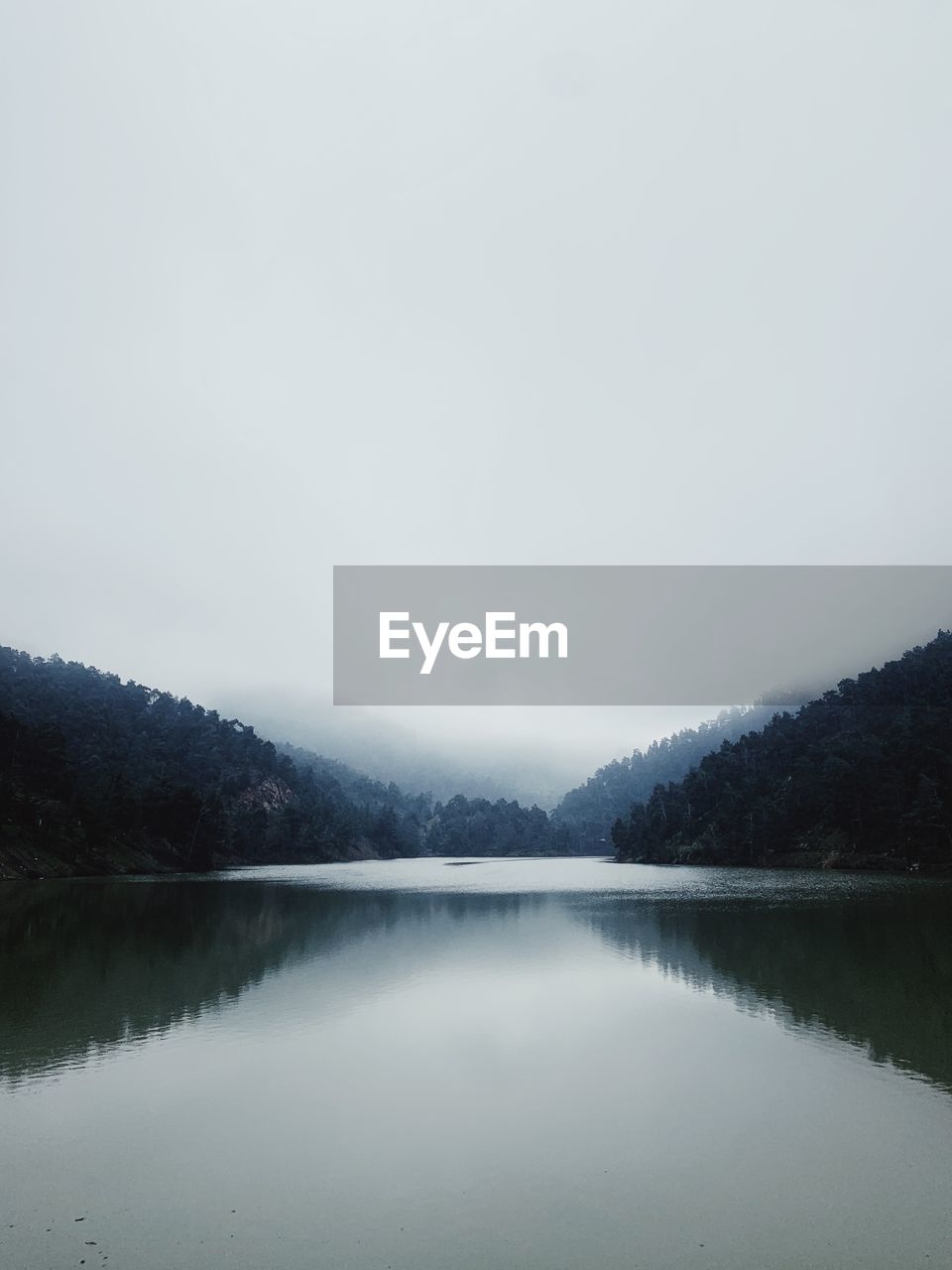 water, reflection, lake, scenics - nature, tranquility, tranquil scene, beauty in nature, body of water, sky, mist, no people, mountain, nature, fog, reservoir, tree, morning, copy space, environment, non-urban scene, forest, cloud, landscape, snow, idyllic, plant, day, remote, land, winter, overcast, outdoors, mountain range