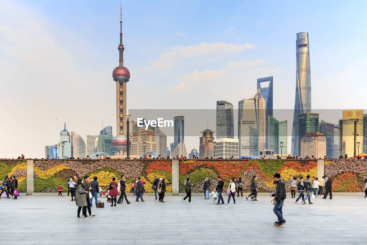 People walking on bund against oriental pearl tower