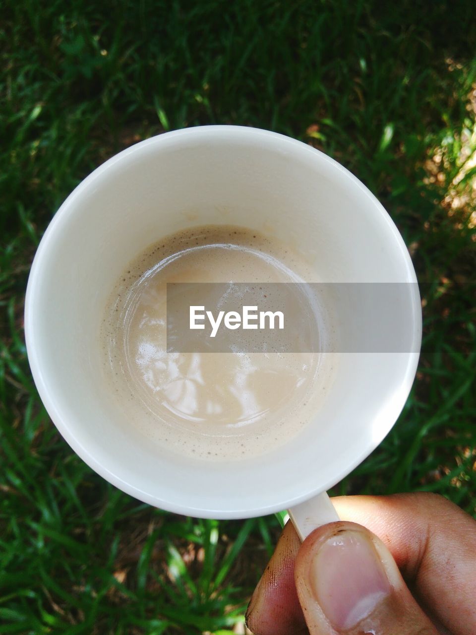 CLOSE-UP OF HAND HOLDING COFFEE