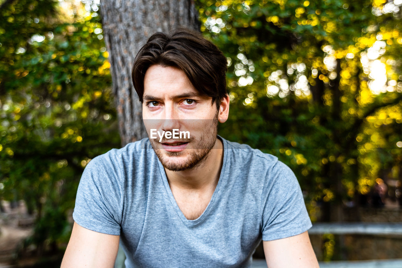Portrait of young man against trees