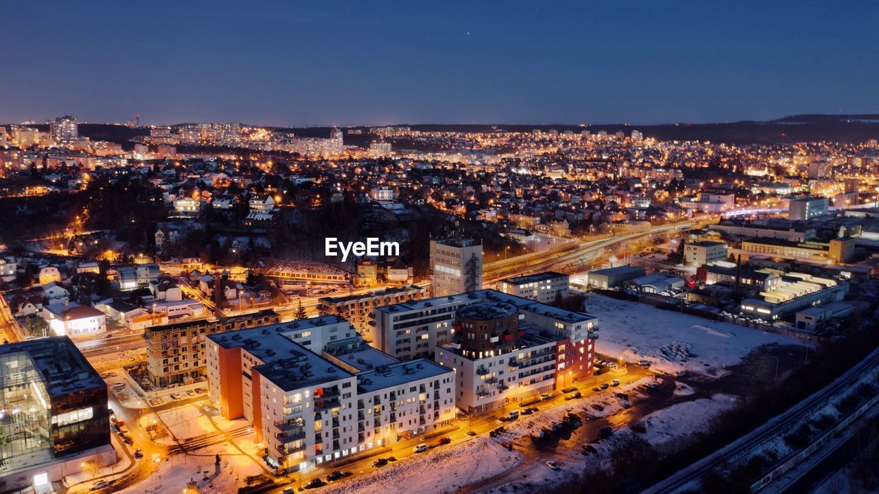 High angle view of illuminated city against sky at dusk