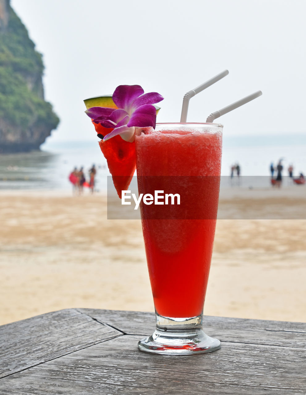 Close-up of watermelon juice on table against sea