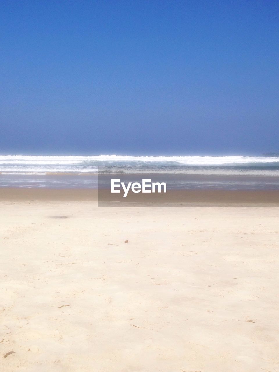 Scenic view of beach against blue sky