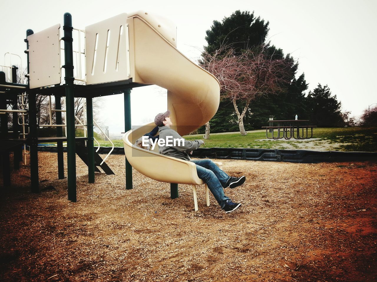 Mother and son enjoying slide at playground