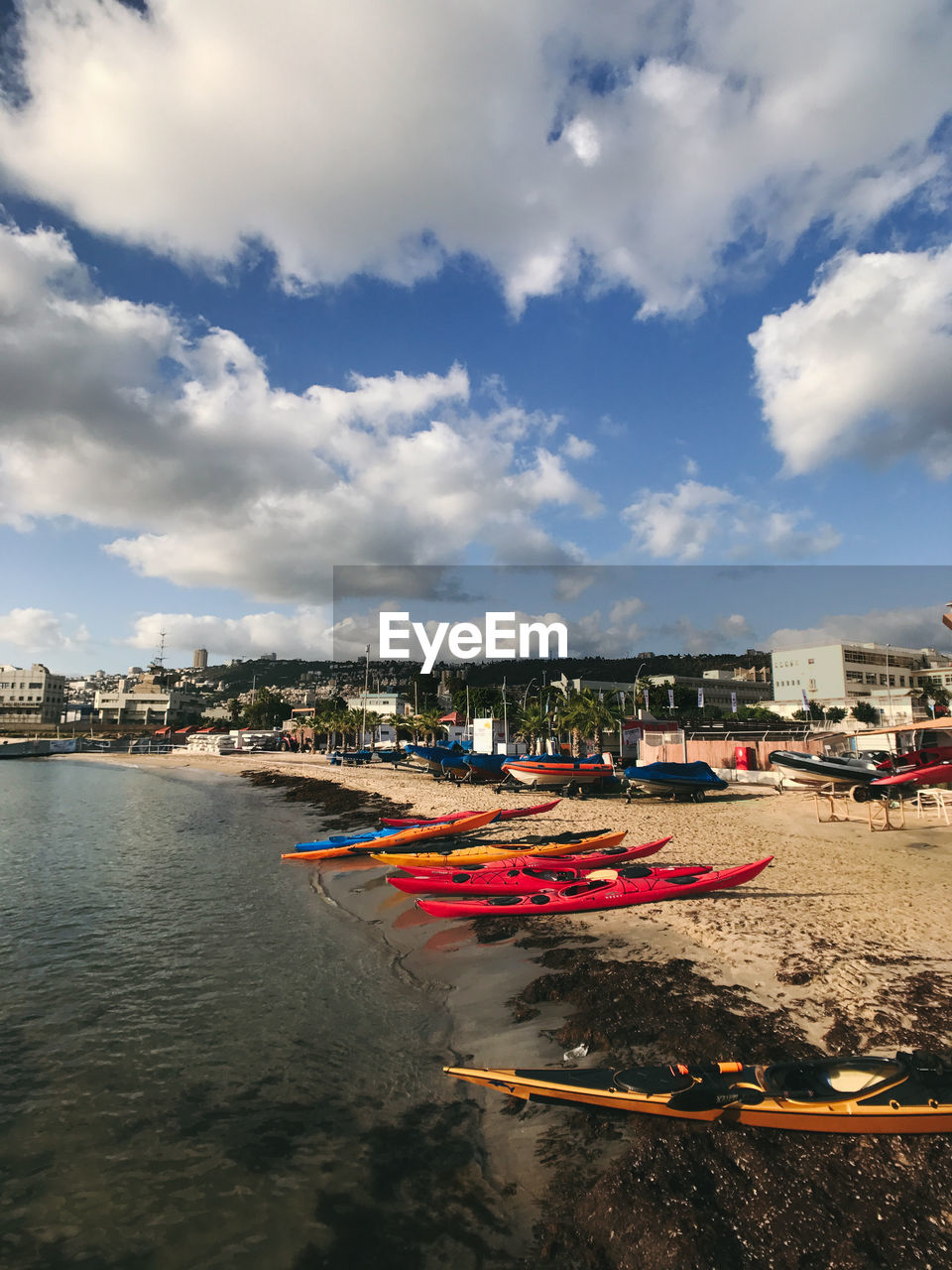 Boats moored in sea against sky in city