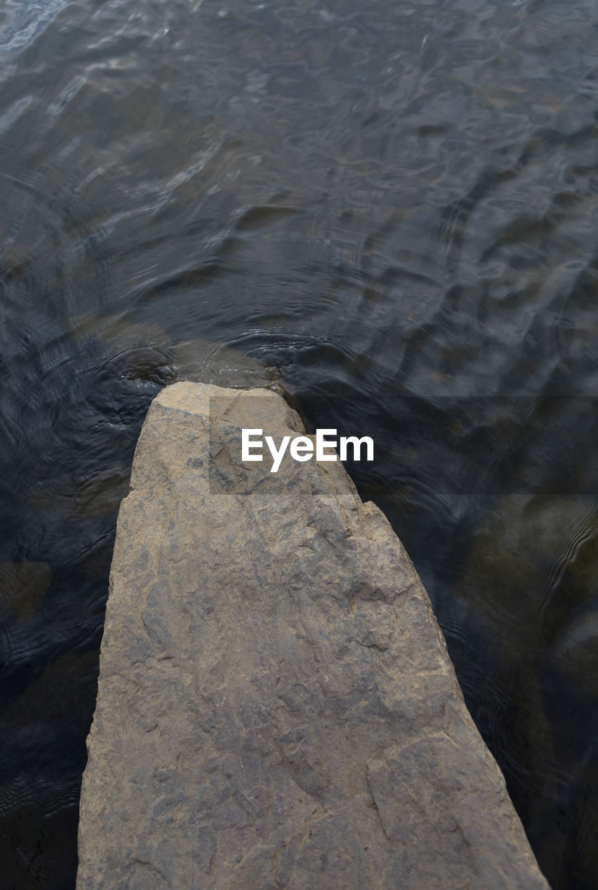 CLOSE-UP OF WATER FLOWING THROUGH ROCKS