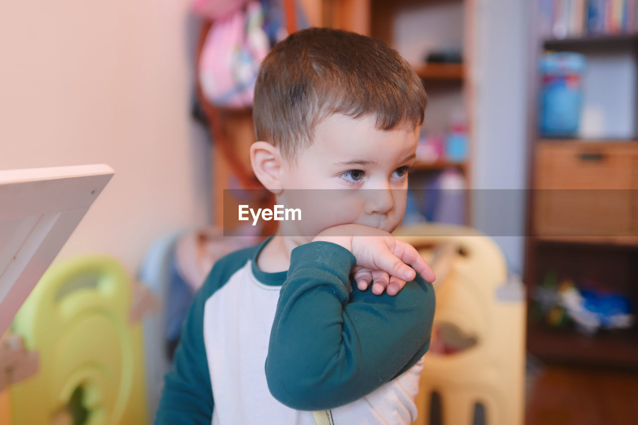 Cute young boy watching intently while bending his wrist