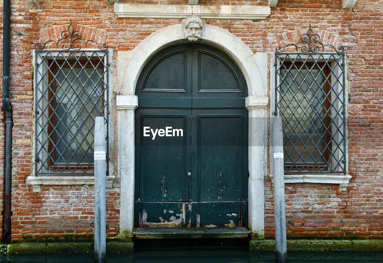 architecture, entrance, building exterior, built structure, door, closed, building, security, protection, facade, window, no people, house, brick, day, brick wall, residential district, arch, outdoors, old, iron, urban area, gate, wall, history, front door, doorway, wall - building feature, the past, city, metal