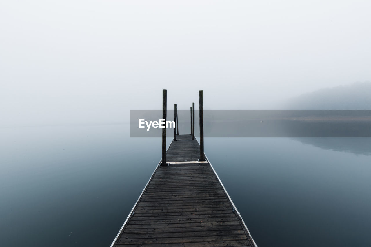 Pier over lake against sky