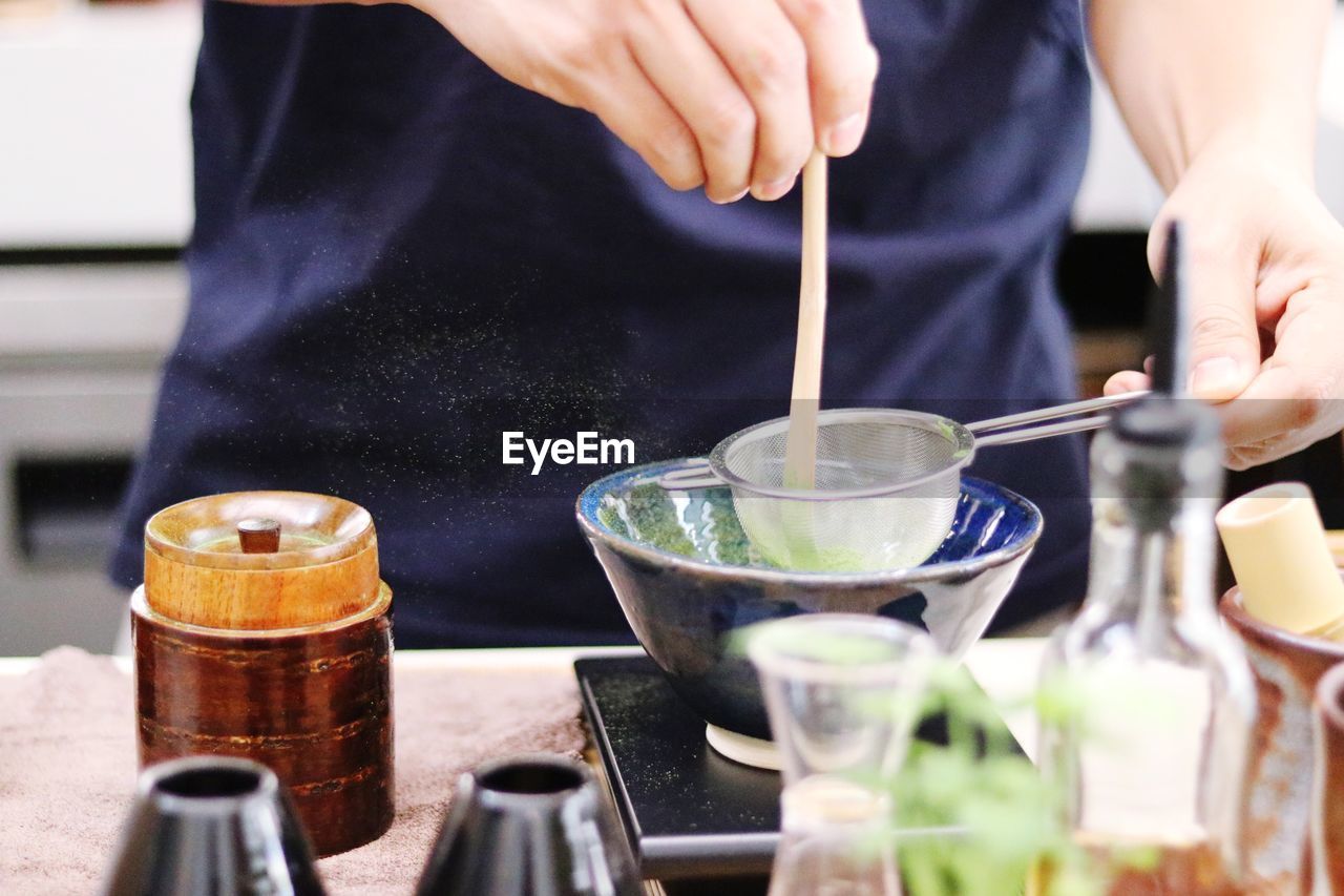 Midsection of man preparing food in glass