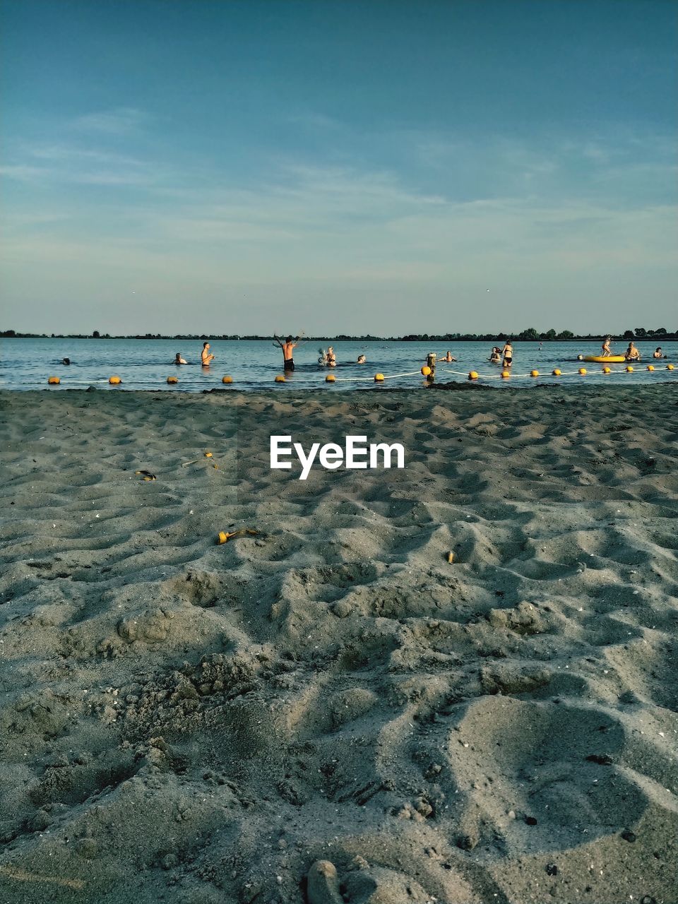 GROUP OF PEOPLE ON BEACH AGAINST SKY