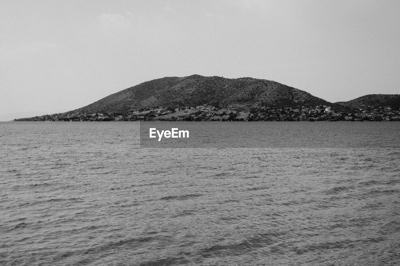 SCENIC VIEW OF SEA AND MOUNTAIN AGAINST CLEAR SKY