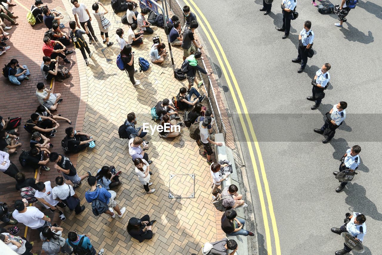 High angle view of people and police officers on street