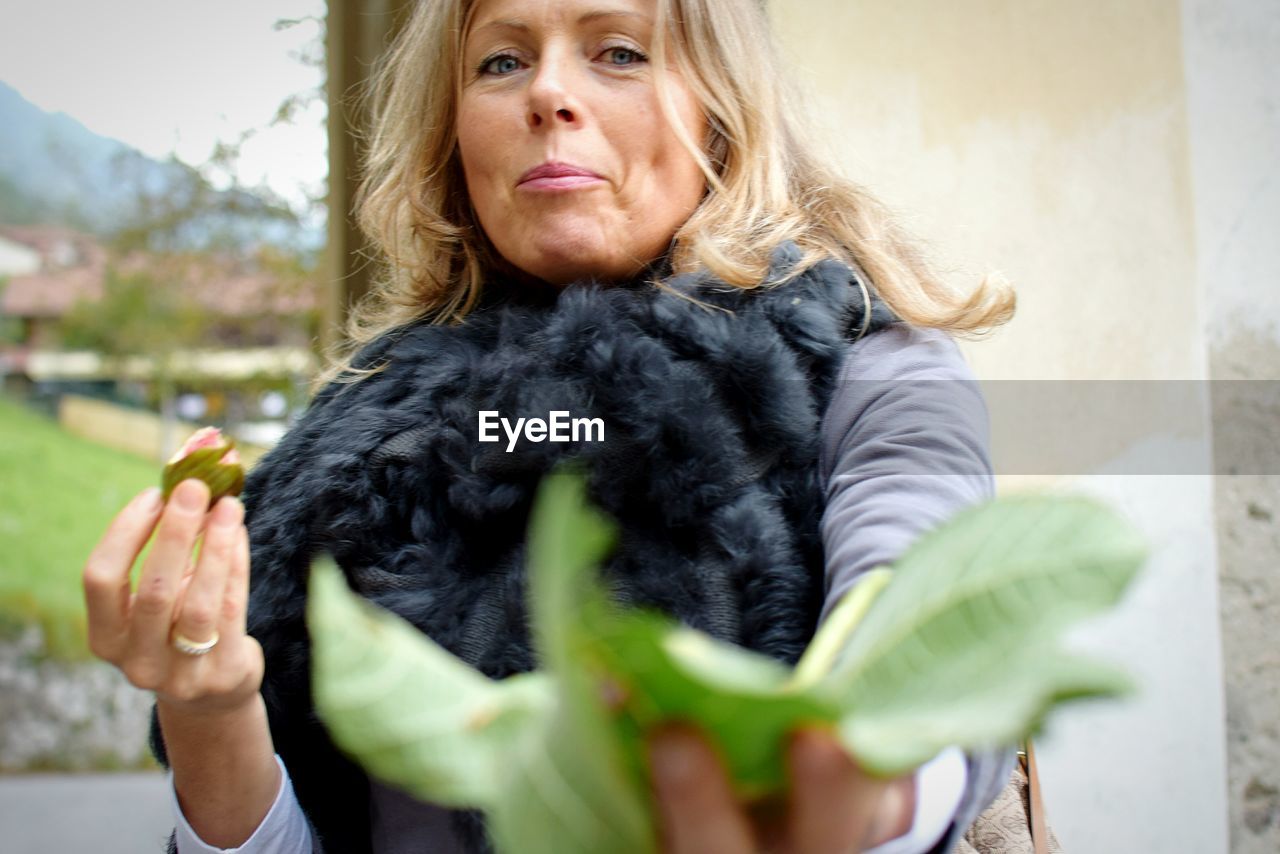 Close-up of leaves held by mature woman