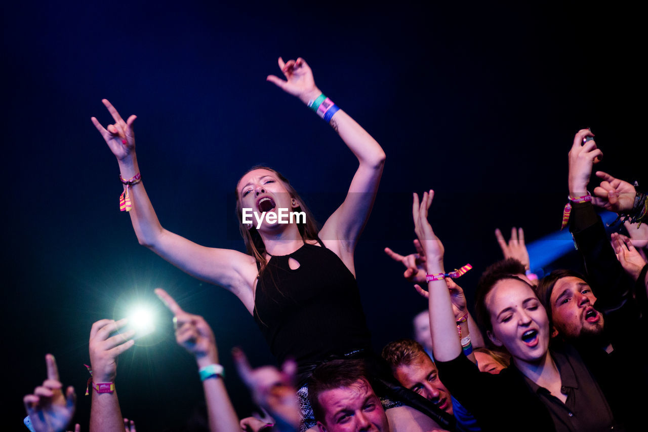 YOUNG WOMAN SITTING ON STAGE AT NIGHT