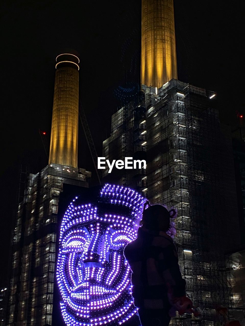 LOW ANGLE VIEW OF ILLUMINATED BUILDINGS AT NIGHT IN CITY