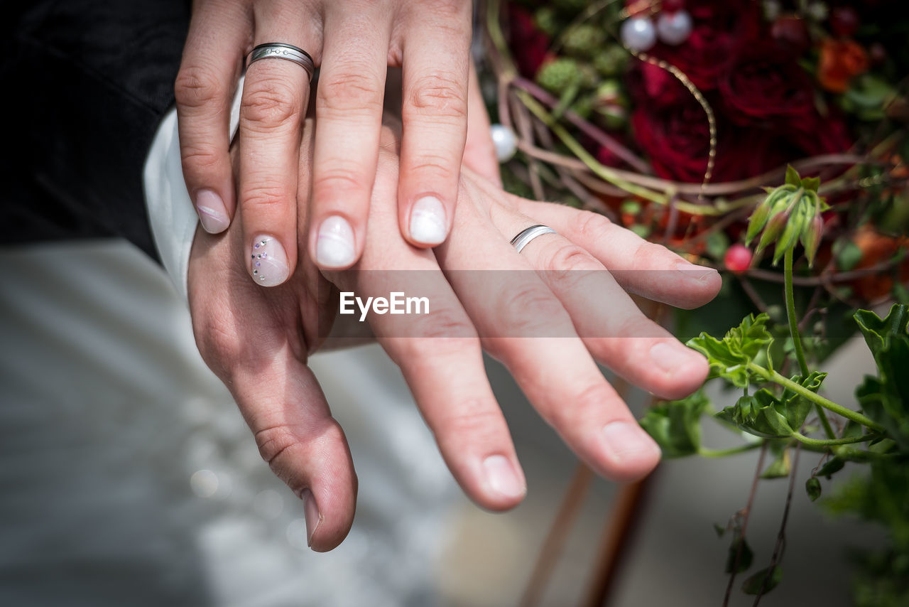 Close-up of couple hand wearing ring during wedding ceremony