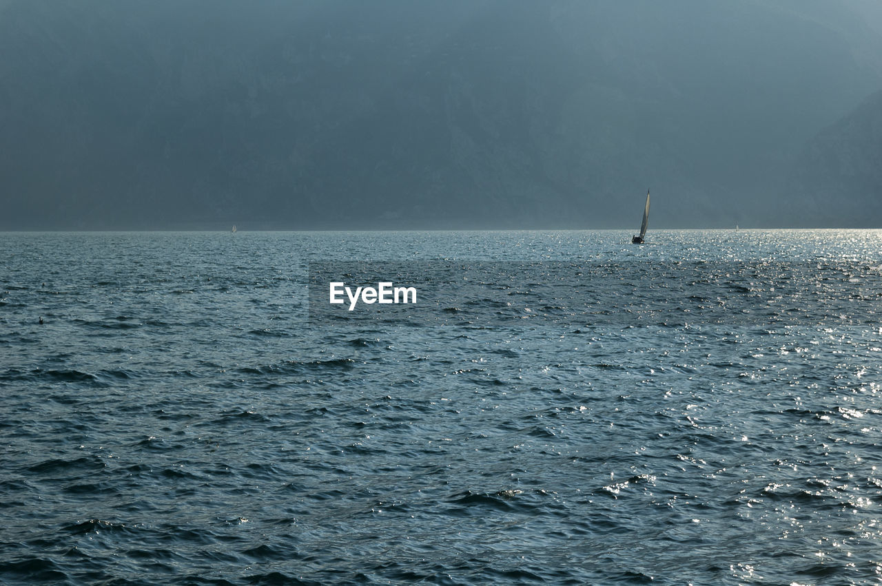 Scenic view of garda lake with small sailboat