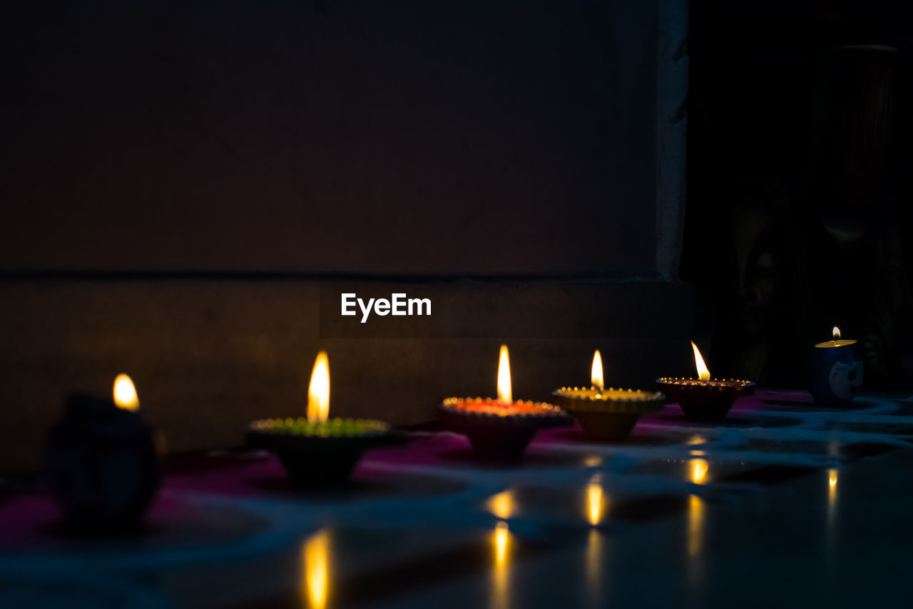 Illuminated tea light candles in building