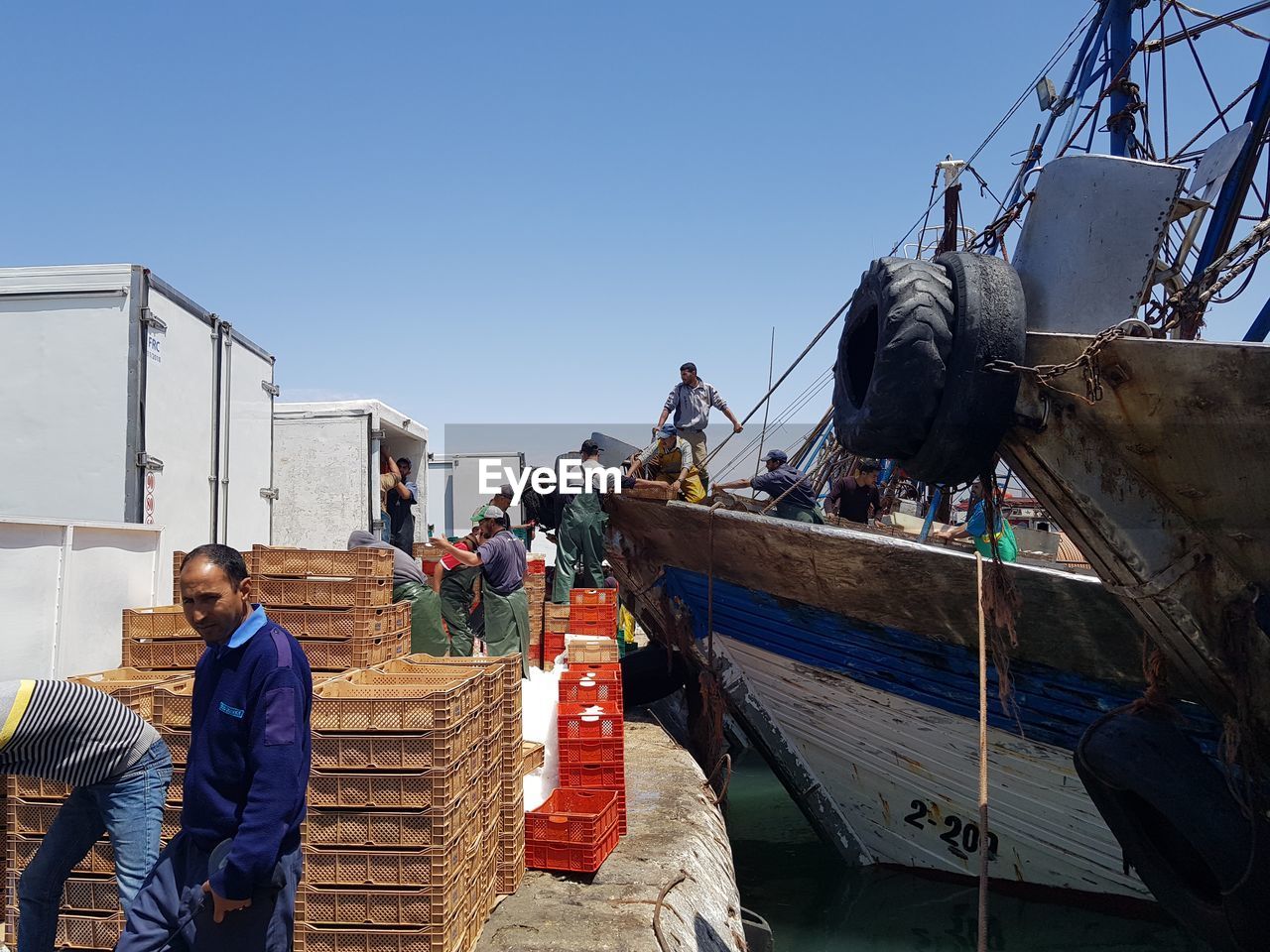 People working on boat against clear sky